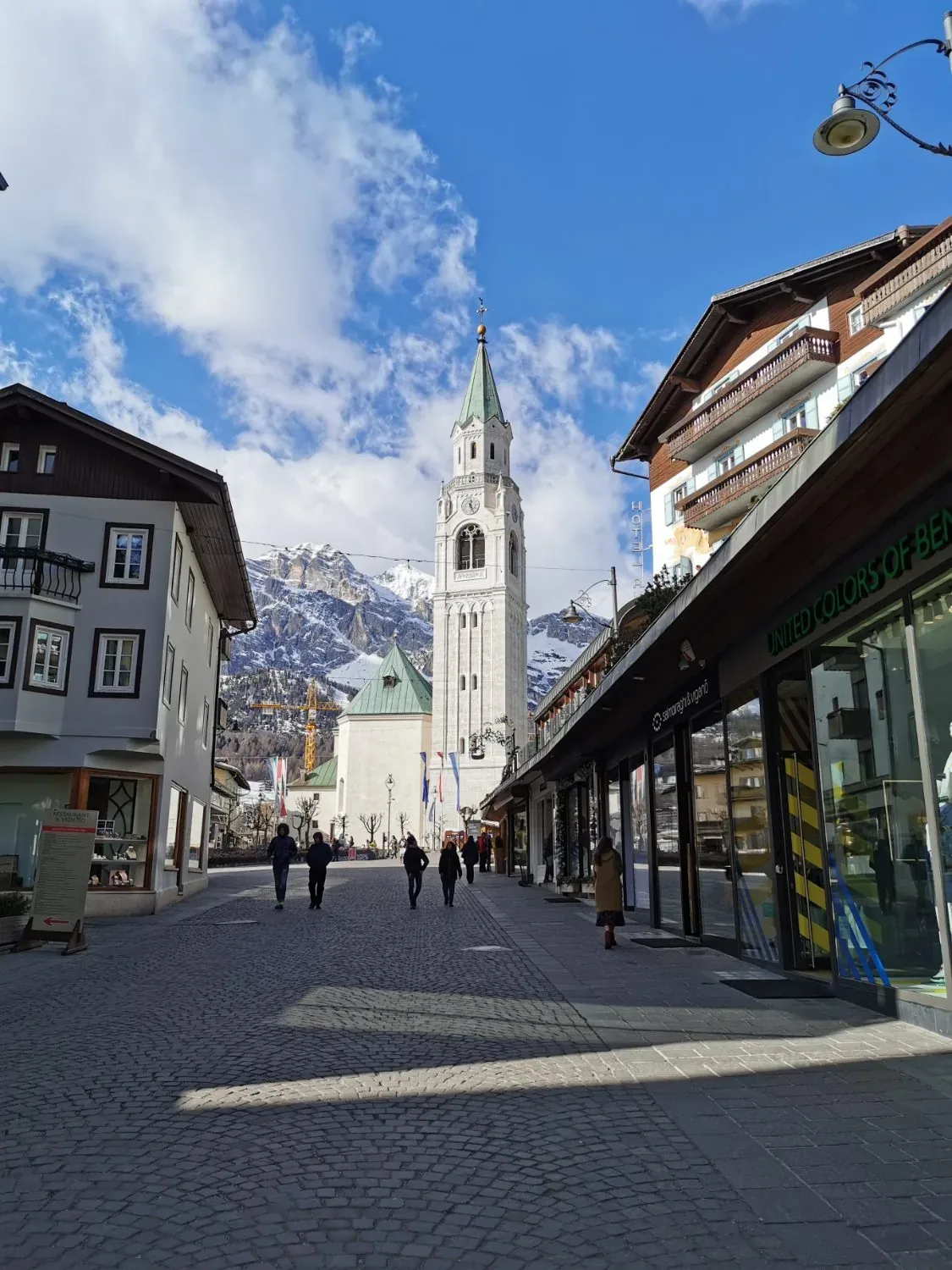 A quiet alpine town square beneath snow-dusted mountains